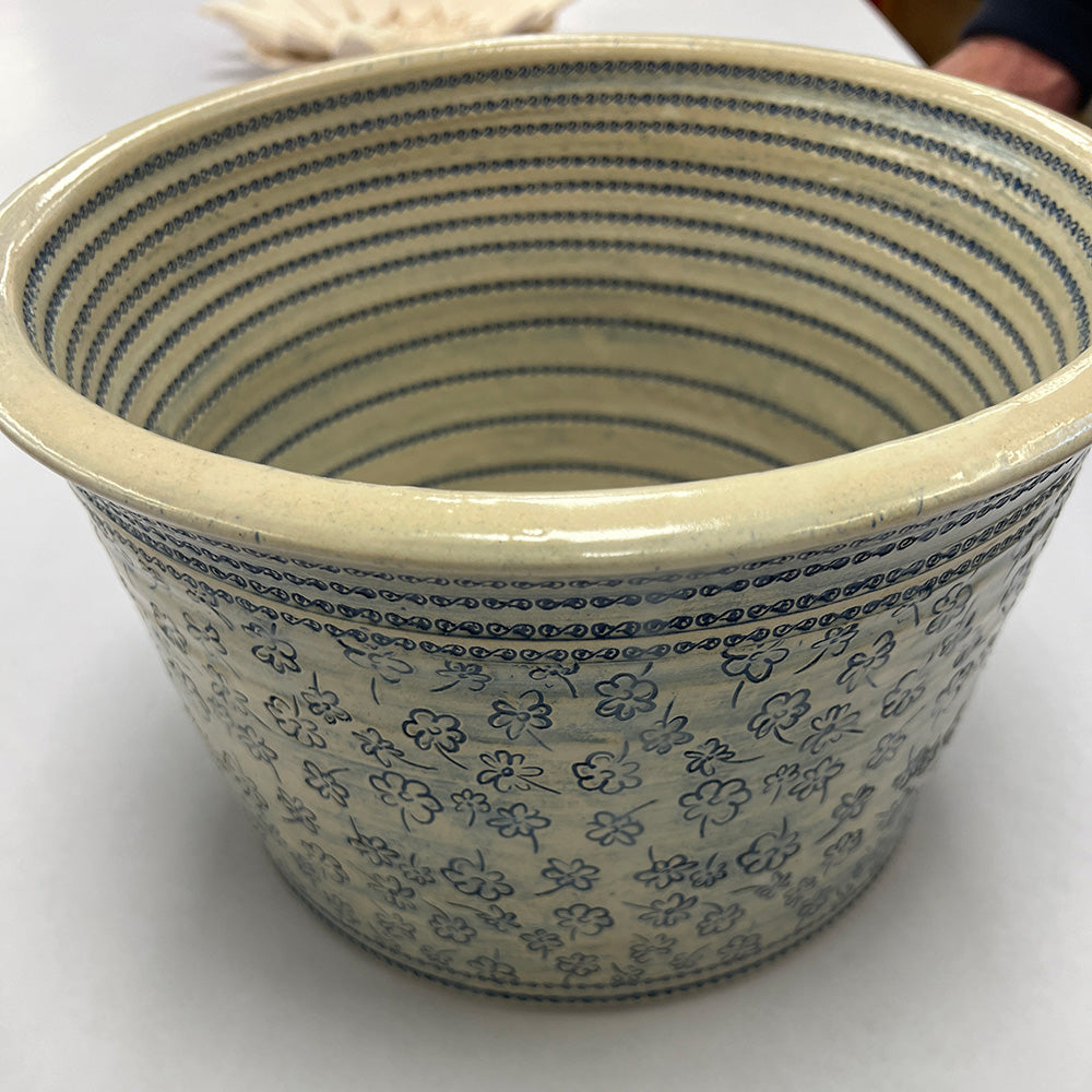 Close-up of a 90mm flower line repeat roller showing intricate flower designs for pottery texturing.